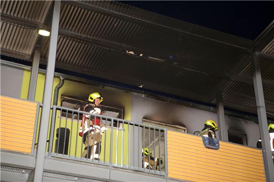 Feuerwehrleute stehen vor einer ausgebrannten Wohnung in Göttingen.