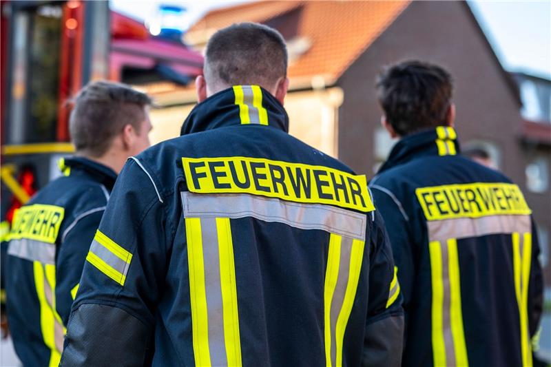Feuerwehrleute stehen zusammen, um den Einsatz zu besprechen.