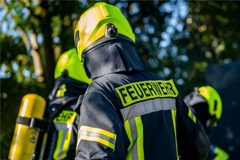 Feuerwehrleute stehen zusammen, um den Einsatz zu besprechen (Symbolbild). Foto: dpa