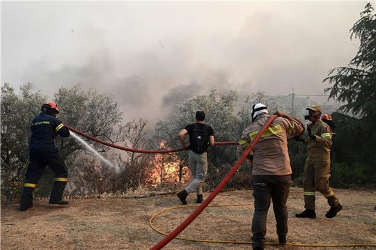Feuerwehrleute und Freiwillige versuchen den Brand bei Nea Anchialos zu löschen.