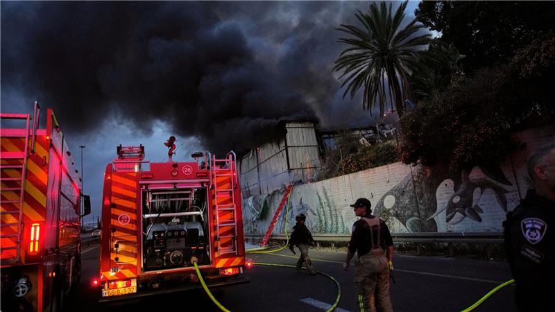 Feuerwehrleute versuchen in Holon in Israel nach einem iranischen Raketeneinschlag ein Feuer zu löschen.