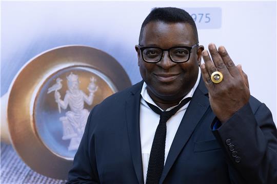 Filmemacher und Preisträger Isaac Julien zeigt den Kaiserring an seinem Finger. Foto: Swen Pförtner/DPA