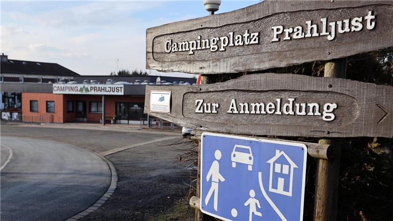 Das Bild zeigt das Hauptgebäude des Campingplatzes Prahljust. Zwei Schilder weisen den Weg zur Anmeldung. Es handelt sich um einen verkehrsberuhigten Bereich.