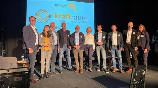 Finale im Kraftraum 2023: (v. li.) Andreas Rotermund (pro Goslar), Moderatorin Jennifer Haacke, Dr. Dirk Schöps (REWIMET), Mike Herrmann (pro Goslar), Guido Sellin (Electrocycling GmbH), Juliane Saupe (H.C. Starck Tungsten), Prof. Harald Zeiss, Frank Schmidt (Media-Markt Goslar), Uwe Schwenke de Wall (pro Goslar), Marina Vetter (Goslar Marketing-Gesellschaft).