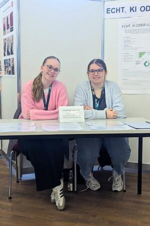 Fiona Feike (l.) und Elena Reinhold an ihrem Stand, mit Infografiken.