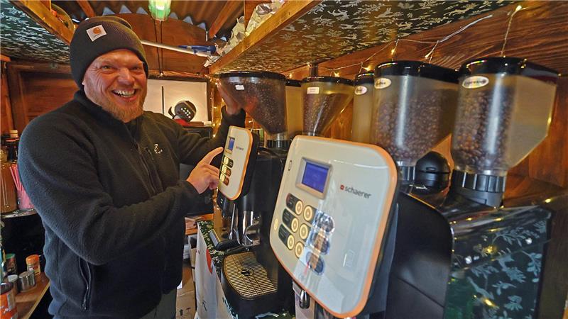 Starker Start für den Goslarer Weihnachtsmarkt Ein Mann mit Mütze steht vor zwei Kaffeemaschinen und drückt auf einen der Knöpfe.