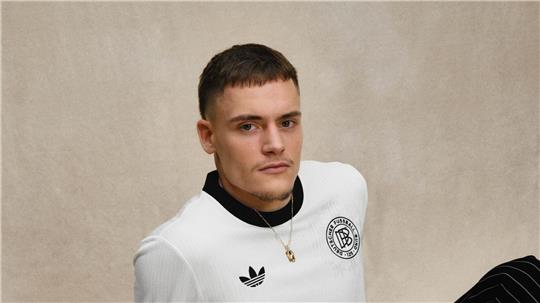 Florian Wirtz posiert mit dem DFB-Retro-Trikot. 