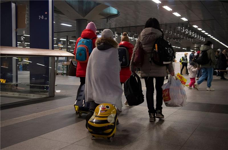 Flüchtlinge aus dem ukrainischen Kriegsgebiet gehen im Berliner Hauptbahnhof zu einer Sammelstelle.