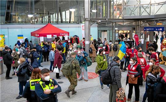 Flüchtlinge aus der Ukraine werden nach ihrer Ankunft am Hauptbahnhof München von Mitarbeitern der Caritas und freiwilligen Helfern empfangen.  Foto: Sven Hoppe/dpa