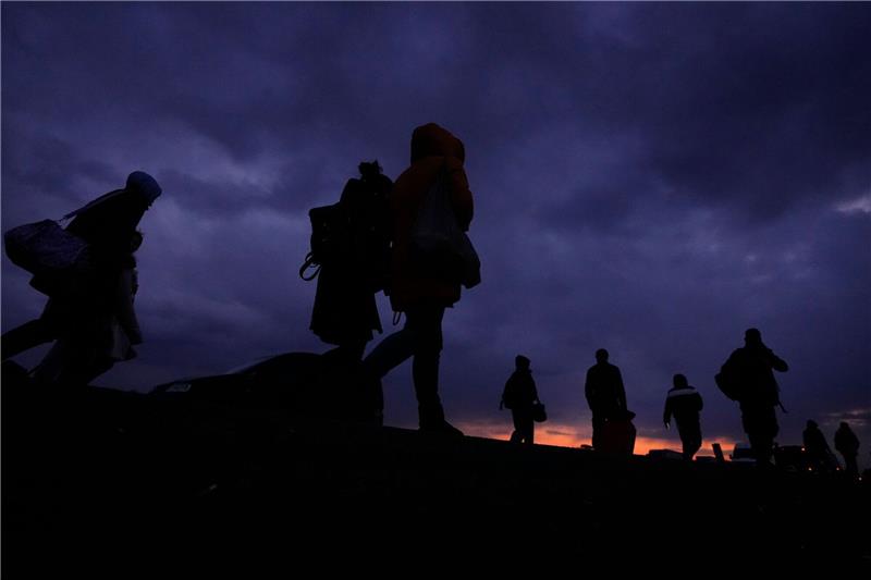 Flüchtlinge, die vor dem Konflikt in der benachbarten Ukraine geflohen sind, gehen mit ihrem Gepäck eine Straße in Polen entlang.