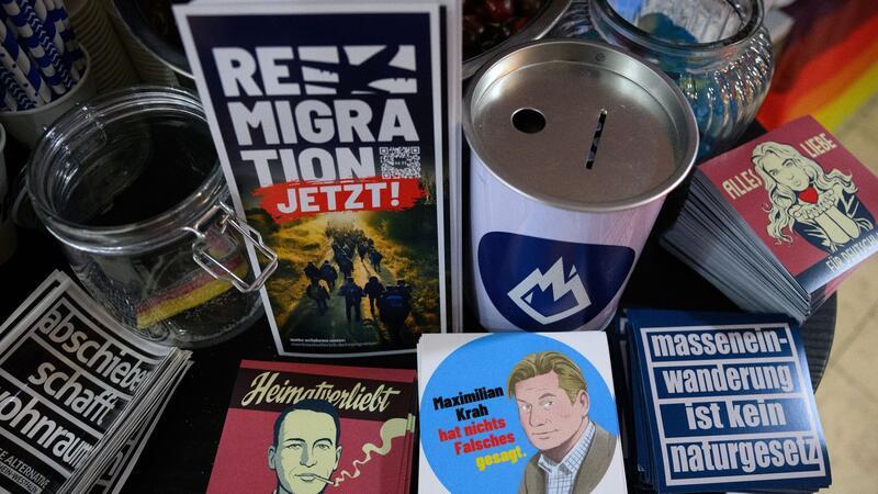 Flyer und Aufkleber mit Slogans wie „Abschieben schafft Wohnraum“ und „Remigration jetzt!“ liegen am Stand der AfD-Jugendorganisation Junge Alternative beim Afd-Bundesparteitag.