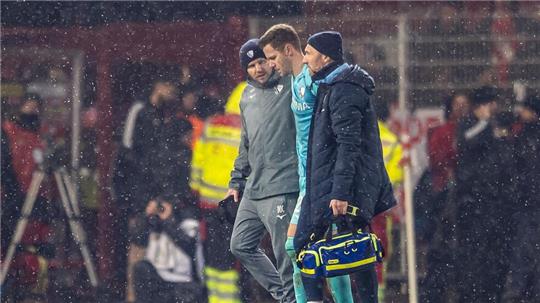 Folge des Feuerzeugwurfs: Torwart Patrick Drewes wird vom Platz geführt.