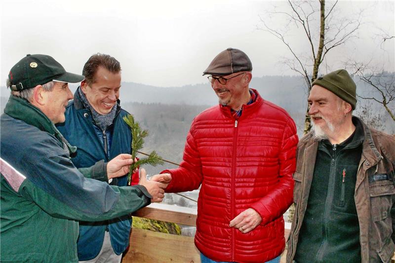 Forstamtsleiter Henning Geske und Bernd Sengstock, Geschäftsführer der Niedersächsischen Naturstein GmbH (NNG), überreichen symbolisch einen sogenannten „Bruch“ an die Wolfshäger Harzklubvertreter, Wanderwart Uwe Brennecke und Wegewart Andreas Habig.  Foto: Leifeld