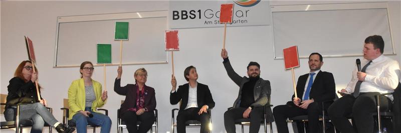 Fragespiel mit Pappschildern: Kreisschülerratsvorsitzender Oliver Fischer (r.) mit den Bundestagskandidaten (v. l.) Peggy Plettner-Voigt (Linke), Karoline Otte (Grüne), Frauke Heiligenstadt (SPD), Dr. Constantin Weigel (CDU), Ali Abo-Hamoud (FDP) und Waldemar Rau (AfD).