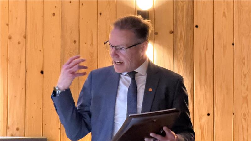 Das Foto zeigt einen Mann, der seine Worte mit seiner Hand unterstreicht.