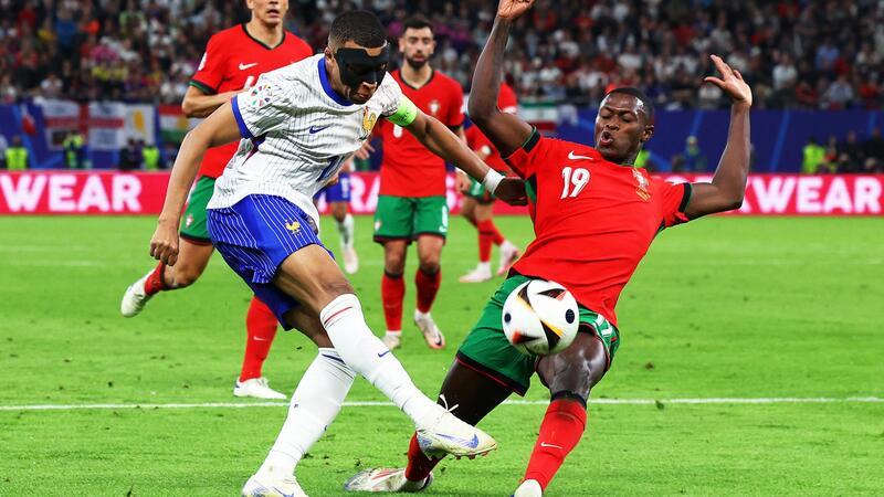 Elfmeterkrimi: Frankreich im EM-Halbfinale gegen Spanien Frankreichs Kylian Mbappé (l) und Portugals Nuno Mendes kämpfen um den Ball.