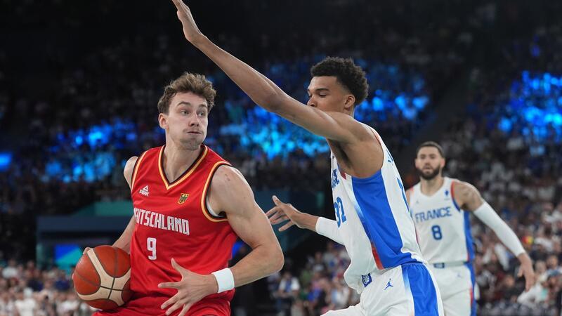 „Kein Videospiel“: Bitteres Aus für Basketballer bei Olympia Franz Wagner attackiert gegen Victor Wembanyama den Korb.
