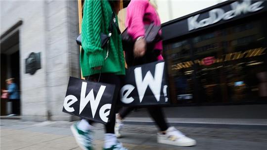 Frauen mit KaDeWe-Tragetaschen gehen am Eingang des Kaufhauses des Westens vorbei.