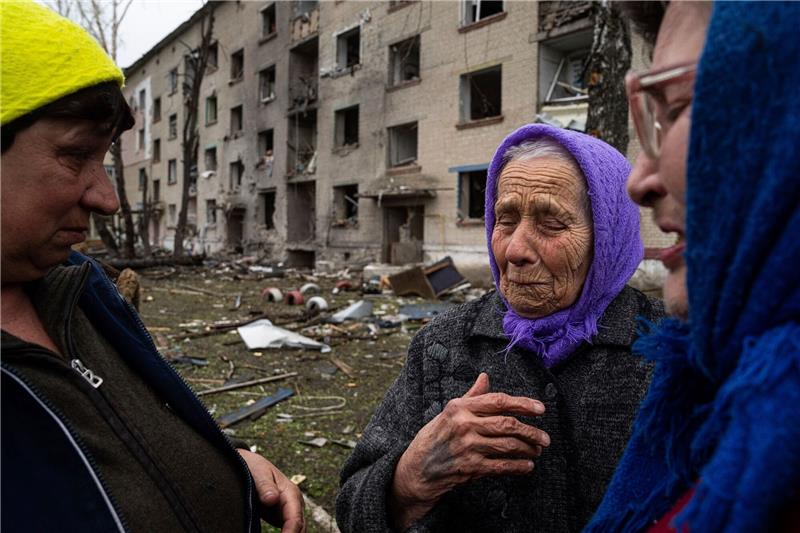 Krieg gegen die Ukraine: So ist die Lage Frauen stehen in Lukiantsi in der Region Charkiw vor einem Haus, das durch einen russischen Luftangriff schwer beschädigt wurde.