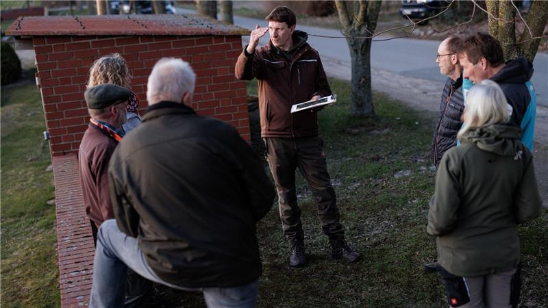 Freiwillige laufen entlang der Felder und zählen die Hähne, die den Revierruf des männlichen Rebhuhnes aus dem Lautsprecher erwidern. Umweltwissenschaftler Marcel Holy (M) erklärt den Ablauf der Kartierung,. 