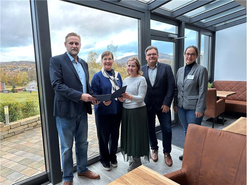 Freudig überreicht Landesbeauftragte Dr. Ulrike Witt (2.v.l.) den Förderbescheid an Marc Kühne (links) und seine Frau Beatrice (Mitte) im neuen Wintergarten des Hotels Brunnenbach. Edda Schaper von der Wirego und Bürgermeister Wolfgang Langer freuen sich ebenfalls über den erfolgreichen Generationswechsel. Foto: Eggers