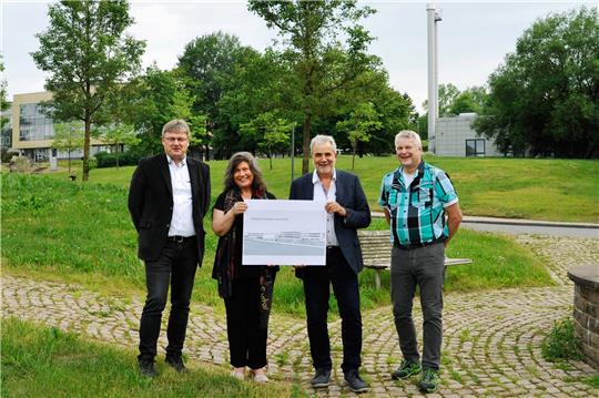 Freuen sich, dass es mit dem Chemie-Campus Clausthal jetzt losgeht (v.li.): Prof. René Wilhelm, Leiter des Instituts für Organische Chemie, die hauptberufliche Vizepräsidentin Irene Strebl, Prof. Arnold Adam, Leiter des Instituts für Anorganische und Analytische Chemie, und Diplom-Ingenieur Thomas Heger, stellvertretender Leiter der Technischen Verwaltung. Auf der Wiese hinter der Straße wird der Neubau des Praktikumsgebäudes entstehen. Foto: Ernst/ TU Clausthal