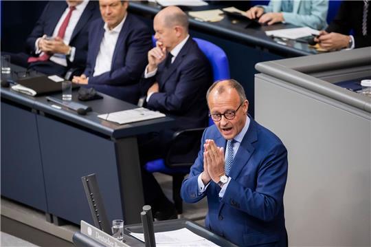 Friedrich Merz (r), CDU-Bundesvorsitzender und Unions-Fraktionsvorsitzender, spricht im Plenum des Deutschen Bundestages vor Bundeskanzler Olaf Scholz (SPD, hinten M).