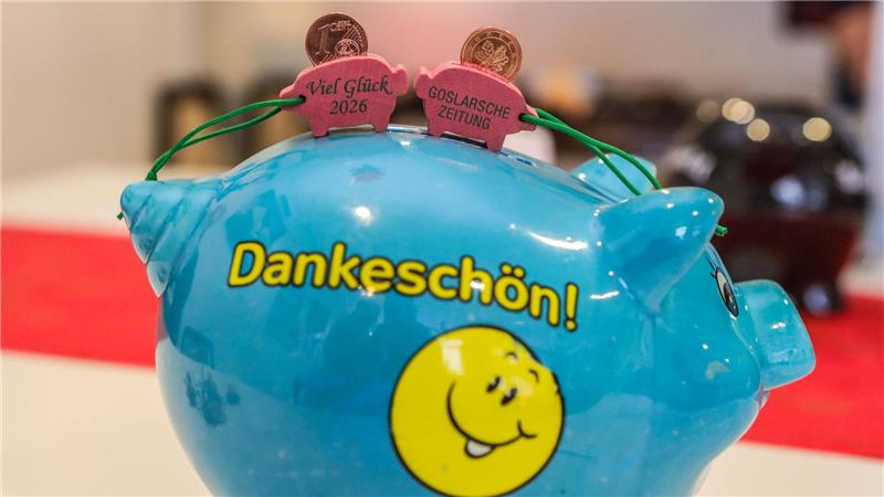 „Dankeschön“ steht auf einem blauen Sparschwein. Darauf sind zwei Glücksschweinchen der Goslarschen Zeitung, die viel Glück für das Jahr 2026 wünschen.