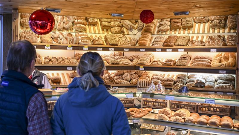 Übersicht: Hier gibt es frische Brötchen an Pfingsten Frische Backwaren: Kunden stehen vor einem gut gefüllten Regal in einer Bäckerei. Foto: dpa