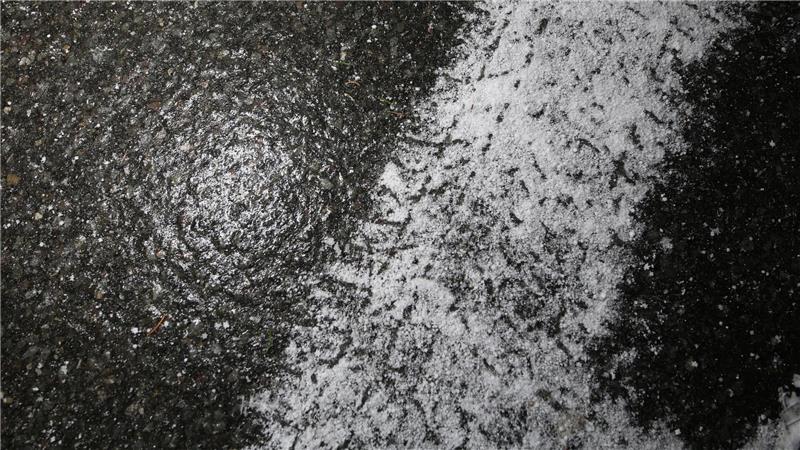 Frische Reifenspuren eines Winterreifens auf spiegelglatter Straße zeigen die winterlichen Straßenverhältnisse im Harz.