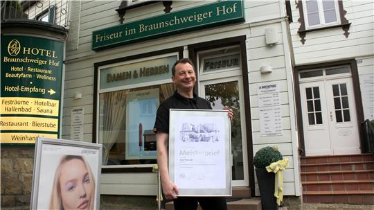 Friseurmeister Uwe Posorski freut sich über seinen silbernen Meisterbrief und das 30-Jährige des Salons.