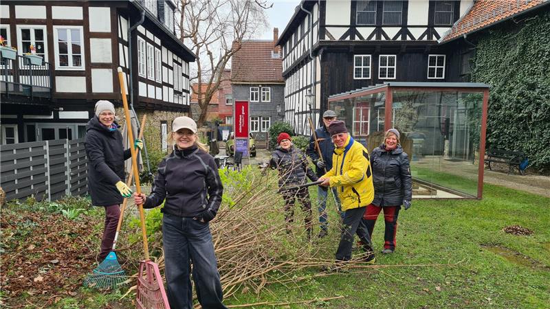 Einige Menschen sind mit Gerätschaften im Garten unterwegs.