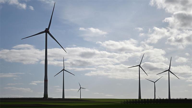 Windräder auf einer flachen Landschaft unter bewölktem Himmel