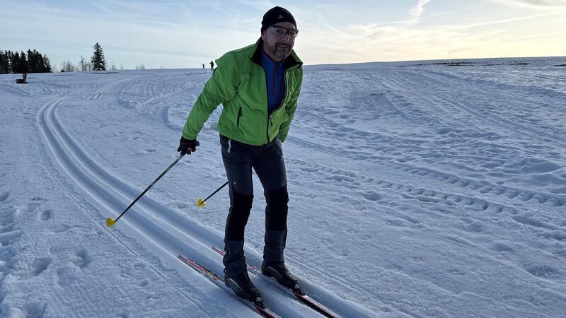Ein Skilangläufer fährt bei Braunlage durch eine gespurte Loipe.