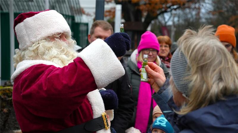 Für die Erwachsenen hat der Nikolaus Geschenke in Form von grünen Schnapsflaschen dabei.