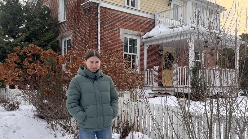 Junge Frau vor Haus im Schnee