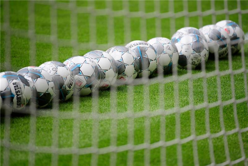 Fußbälle liegen im Tor.