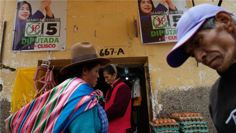 Fußgänger gehen an Wahlkampfplakaten in Cuzco in Peru vor den Präsidentschaftswahlen am Wochenende vorbei.