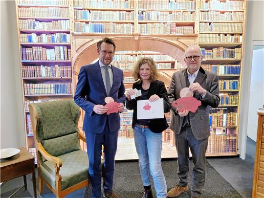 GZ-Verleger Philipp Krause (links) übergibt einen Teil der Glücksschweinchen-Erlöse an Sonja Weber und Dirk Junicke. Insgesamt wurden diesmal 39.000 der kleinen Holzanhänger von Mitarbeitern der Lebenshilfe produziert und durch die GZ verkauft. Fast 51.000 Euro können dank der Schweinchen jetzt an gemeinnützige Projekte fließen. Foto: Exner