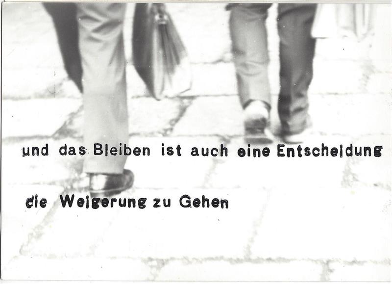 Auf einer Schwarz-Weiß-Postkarte sind die behosten Männerbeine beim Gehen zu sehen; darunter steht der Text "und das Bleiben ist auch eine Entscheidung - die Weigerung zu gehen"