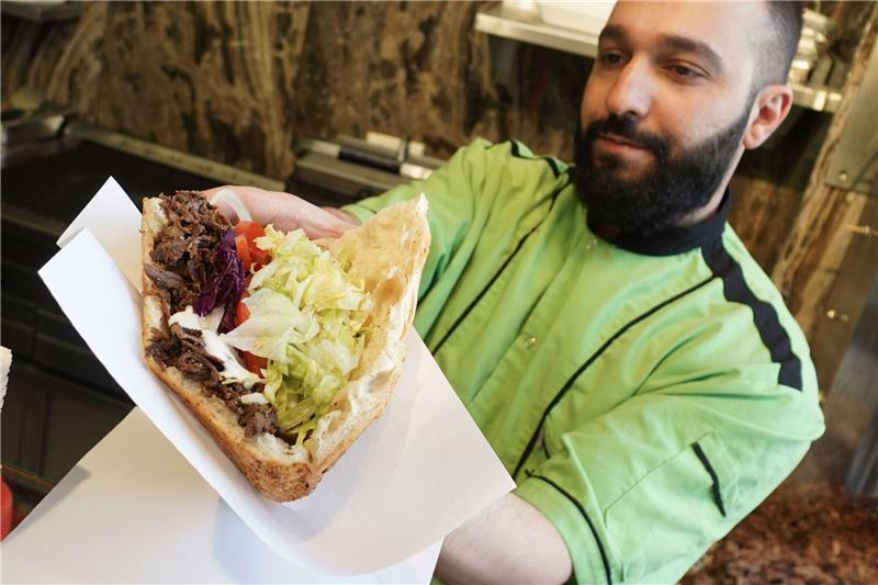 Galip vom Imren Grill in Berlin bereitet einen Döner zu.