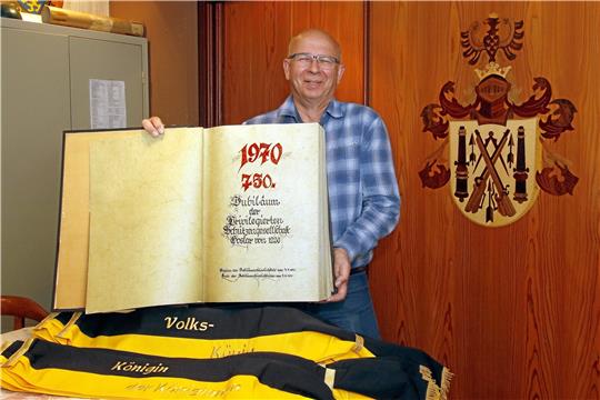 Geballte Tradition: Schützenvogt Wolfgang Graßl präsentiert im Vorstandszimmer einen Band, in dem die Feierlichkeiten zum 750-jährigen Bestehen dokumentiert werden. Rechts auf dem Holzschrank das Vereinswappen als Intarsienarbeit. Foto: Epping