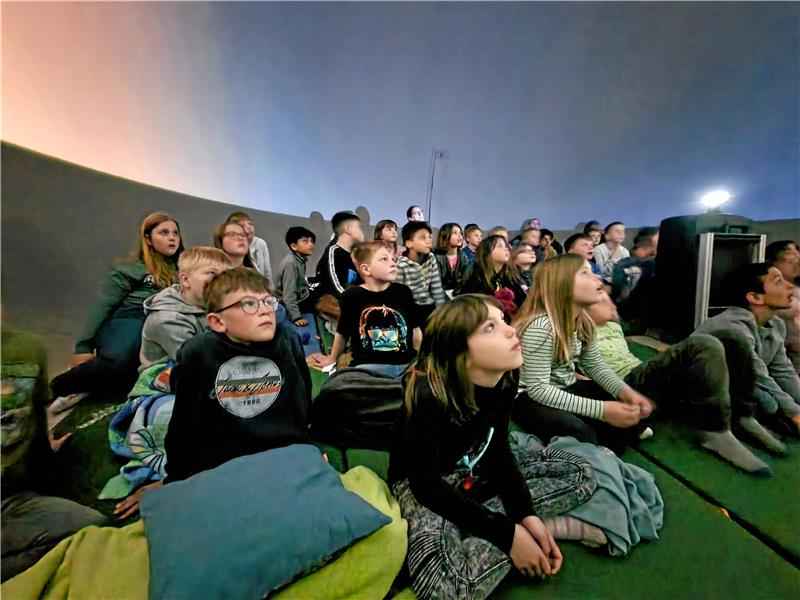 Gebannt schauen die Kinder nach oben und suchen die Sternenbilder. Foto: Knoke