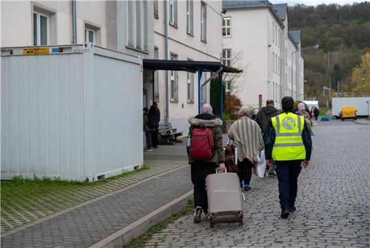 Geflüchtete kommen an einer Asylunterkunft in Trier an. Vor dem Spitzentreffen von Bund und Ländern hat der Städtetag auf die Probleme bei der Unterbringung von Geflüchteten hingewiesen.