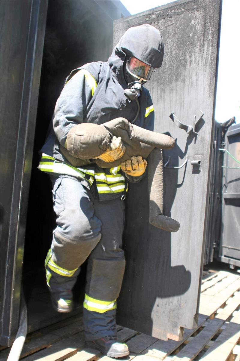 Gefunden: Im ersten Container sind fünf Dinge versteckt, die bei dunklem Rauch gesucht werden müssen – unter anderem eine Puppe so schwer wie ein Kind. Im zweiten Container (ovales Bild) üben die Feuerwehrleute die Löschtechniken.  Fotos: Knoke/Privat