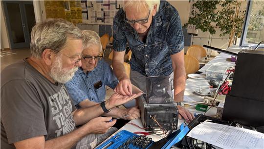 Gemeinsam versuchen Torsten Schriefer, Dieter Möller und Rolf Risse das Problem zu finden, warum die Klappe des CD-Players nur stotternd öffnet. (v.l.)