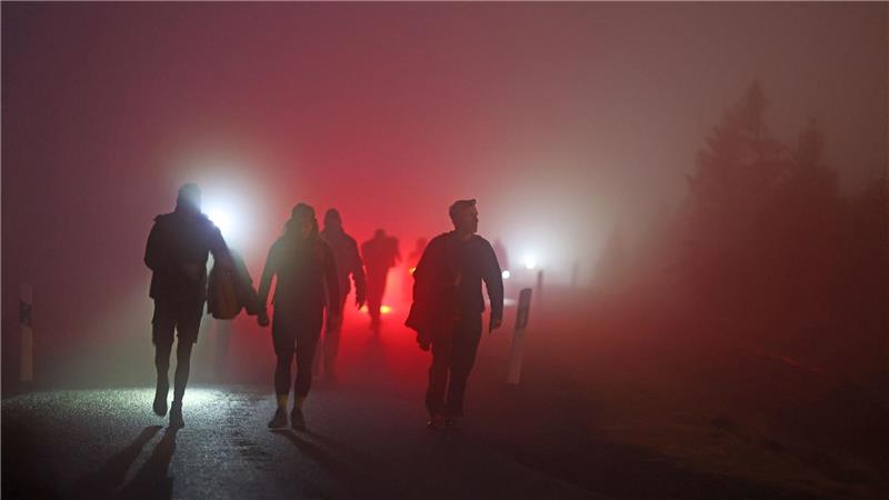 Geocacher kommen vor Sonnenaufgang auf den Brocken im Harz.