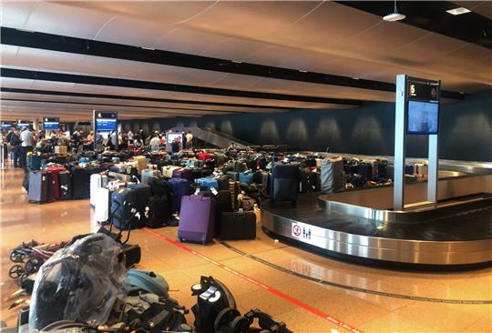 Gepäckstau am Flughafen Hamburg: Gestrandete Koffer stehen neben Kofferbändern. Foto: Michael Rummler/DPA