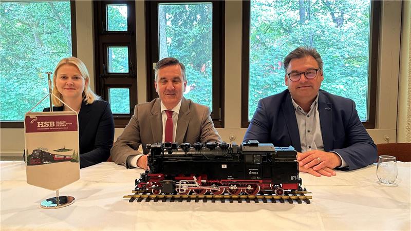 Das Foto zeigt drei Menschen vor einer Modell-Lok.