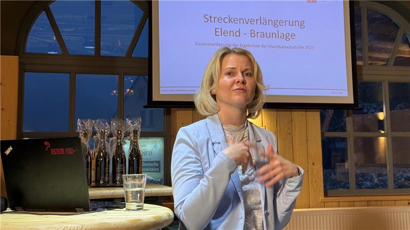 Das Foto zeigt eine Frau vor einer Leinwand, die etwas erklärt.